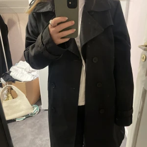 Svart trenchcoat - Svart oversized trenchcoat i bra, tjockt material. Köpt på Sellpy, men är i fint skick. Säljer då den tyvärr aldrig kommit till användning(lapp kvar, skärp medföljer)🥰