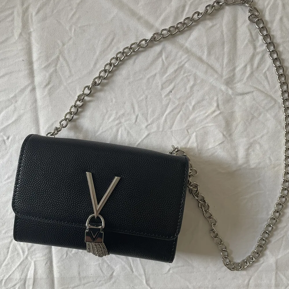 En svart Valentino väska med detaljer i silver. Säljer den för att silver inte är min färg.  Använd 1 gång.   Kan mötas upp i Västerås eller så betalar köparen frakt. Tar endast emot Swish 💨 . Accessoarer.