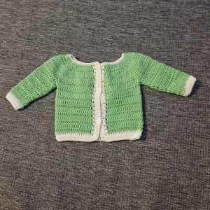 Baby tröja - Denna fina mysiga tröja har jag virkat. Garnet är av bomull. Tvättas i 30 grader. Passar barn vid nyfödd. Finns i rök och djurfritt hem. Köparen står för frakten
