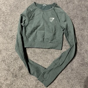 Gymshark träningstopp - Långärmad croppad träningströja från gymshark som aldrig är använd och därför i jättebra skick. Kan strykas innan postning om det önskas. Pris kan diskuteras.