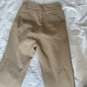 HELT NYA beiga byxor  - Jättefina byxor från Gina Tricot i strech material, lite rakare i modellen. Storlek 34
