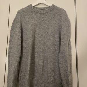 Stickad tröja - En stickad tröja ifrån HM i färgen grå. Knappt använd, köpt för 300kr. Köparen står för frakt och priset går att förhandla 