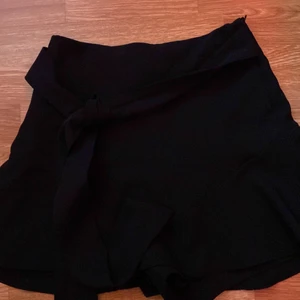 Kjol - Köp inte direkt! Jätte gullig Svart kjol från Zara. Väl använd men fortfarande i perfekt skick! Dragkedja finns på sidan och midje band på varsin sida av höfterna. pris kan diskuteras💕 (köparen står för frakt)