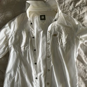 G star skjorta - Vit G star skjorta i bra skick. Knappar på framsidan. Väldigt casual skjorta och kan användas vardagligt samt för finare tillfällen.