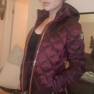 Canada snow höst/vinterjacka  - Figursydd, med snygga detaljer i en mörk vinröd färg. Storlek Small 