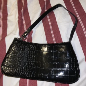 Svart väska  - Säljs då den inte längre används, har några små märken (se de andra bilderna). Knappt använd, frakten är 26kr, köparen står för frakten!