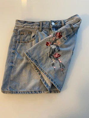 Blommig jeanskjol - Blommig jeanskjol från Cubus. Lite sliten (tredje bilden) som inte syns mycket. Som kompensation sänker jag priset. Köparen står för frakten 💕