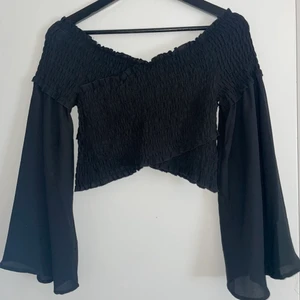 Topp/blus - Svart croppad topp med genomskinliga ärmar, storlek S, säljs för 90kr