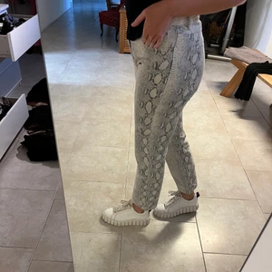 Jeans med snakeprint - Jeans från Gina Tricot med snake print. Säljer för att det inte kommer till användning. Väldigt bra skick då det inte är använda mer än ett fåtal gånger!