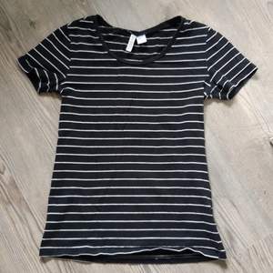 Svart t-shirt med vita ränder från H&M i strl S. 95% bomull 5% elastan.