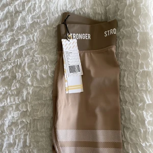 Träningstights  - Ett par sprillansnya träningstights från stronger i en nude färg. De är endast testade 
