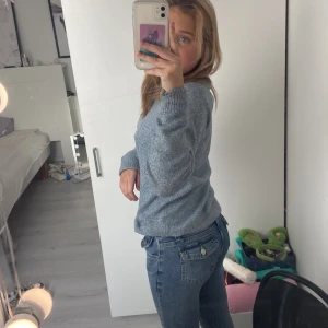 Jeans  - Ett par utsvängda jeans som är typ lågmidjade 