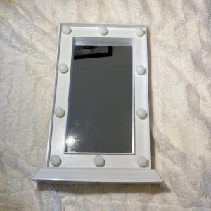 Vit spinkspegel med lampor  - En fin liten smink spegel till salu, då jag fick en ny till min födelsedag. Bra skick och själva spegeln är inte sönder eller skadad. Den har tändknapp på sidan och gulliga små lampor runt. Batteri ingår,men du kan såklart byta själv. Du står för frakten❤️