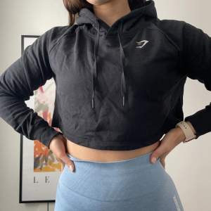 Gymshark training cropped hoodie i färgen black. Äldre modell, sparsamt använd, storlek M. Liten i storleken.