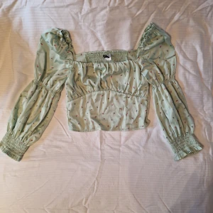 Söt blus med blommor - Silkig blus i turkos. Storlek 38