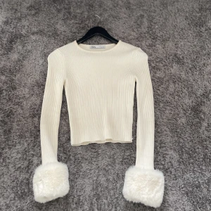 Fluff tröja - Säljer min vita ribbade tröja med otloligt len päls på ärmarna som är i bra kvalitet och lossnar inte lätt alls. Perfekt längd på den. NYPRIS: 500kr