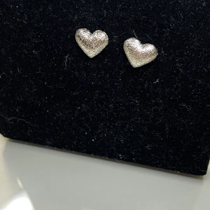 Örhängen silverhjärtan - Örhängen som silverhjärtan med lite skrovlig yta, nytt skick. ej äkta silver. FRAKT 13 KR