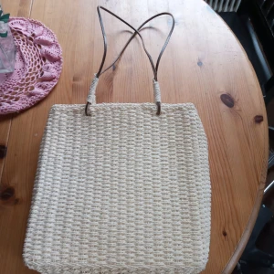 Väska natur vit - Fin väska i naturmaterial vit med läderremmar innefoder samt knäppes med dragkedja .hämtas i Skene alt skickas o köpare betalar frakten o Swishbetalning tillämpas .