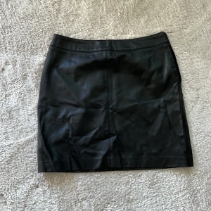 Kjol med skinnimitation - Kort kjol med skinnimitation, bra skick!  Köparen står för frakten🥰