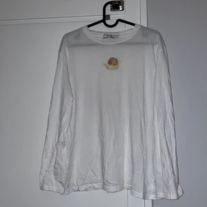 Vit långärmad tröja - Fladdrig vit tunn långärmad med ängeltryck (cherub typ??). bra skick! något urtvättad. frakt ej inkl i priset.