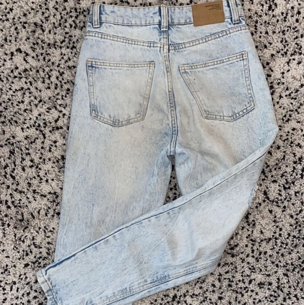 Dessa ljusblåa momjeans med hål i är köpta från NewYourker. Jättebra kvalite, men efter som att momjeans inte riktigt är min stil så säljer jag dessa! Sitter lite löst runt midjan men sitter bra! Sällan använda och kvaliten är super! Känns som helt nya!. Jeans & Byxor.