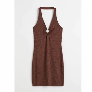 Brun halterneck klänning - Brunmönstrad halterneck klänning med metallring. Helt ny, med prislapp kvar!
