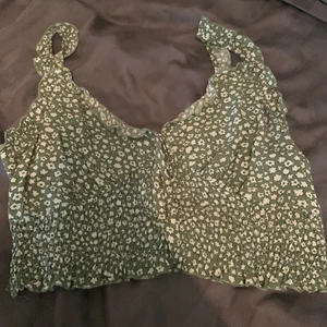 Linne/topp - En grön topp med vita blommor från shein i storlek L. Liten för mig vid bysten, har C kupa och den sitter tajt för mig där. Så jag skulle säga att den är liten i storleken. Fint skick och använd 1 gång, sen endast testad. Köparen står för frakten. 
