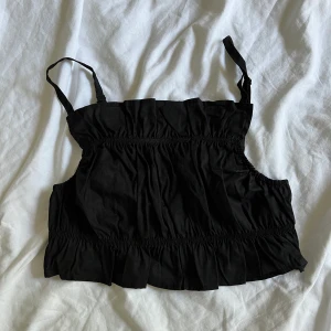 Kort svart top  - En kort svart top, aldrig i användning  Lappen kvar 