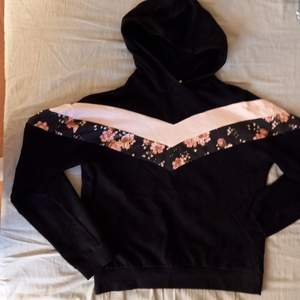 Svart mönstrad hoodie utan fickor och snören! Blommig och rosa mönster. Säljer då jag inte använder den :)