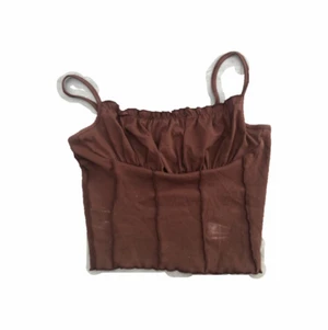 brunt y2k topp - brun topp med huge y2k vibbar😩 så fint men får aldrig användning för det. har en liten vit fläck som ja vet går bort i tvätten (tvättas nu), annars i bra skick!