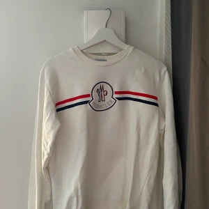 Moncler sweatshirt vit - Vit Moncler sweatshirt. Väldigt fin och bra skick, inte använd så många gånger. Tag finns dvs scanningskod. Skriv för fler bilder. Skriv för pris och inget pris är hugget i sten. Storleken är 1-2 dvs S-M