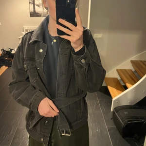 Svart jeansjacka - Så fin svart jeansjacka från Prettylittlething. Oversized modell med skärp att knyta i midjan & silvriga detaljer. Perfekt året om & passar till allt!! 🖤 står ingen storlek i men skulle säga att den passar S/M beroende på vilken passform man vill ha