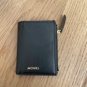 Svart plånbok från Monki - Oanvänd plånbok från monki. Den har mycket utrymme och fickor. 