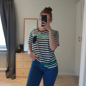 Randig t-shirt - Randig t-shirt med svarta, vita och gröna ränder. Mjukt tyg. Storlek M/L