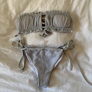 Helt ny oanvänd bikini strl S, passar M - Helt ny aldrig använd silvrig bikini med silver stenar i stolek S, passar även XS/M då den är justerbar på alla sätt o vis. Intimskydd kvar, pads, justerbara band i rygg och runt höfter. Frakt 26kr🥰