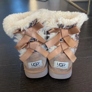 Uggs barn  - Äkta uggs i st 28 (alltså för barn). Lite slitna där fram men väldigt fina, dom är i leopard mönster och fluffiga inuti har också rosetter där bak.