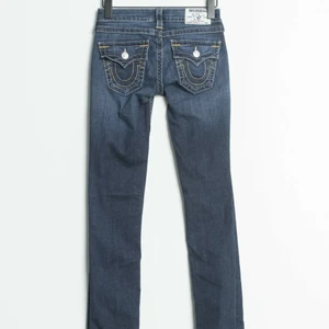 True Religion jeans - Ett par mörkblåa jeans från True religion. Jeansen är bootcut och är lite för långa för mig som är 160 cm. Jag säljer pga att de inte passar mig. De är i storlek 25 men passar xs/s. Man ser inte hela byxorna på bilderna. Om du är intresserad eller vill se egna bilder får du gärna skriva privat :) 
