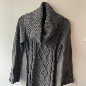 Koftklänning, xs - Längre grå kofta/ klänning med stor krage med knappar. Materialet är gosigt med kabelstickat mönster. Från MQ för 499:-. Dock många år på nacken.