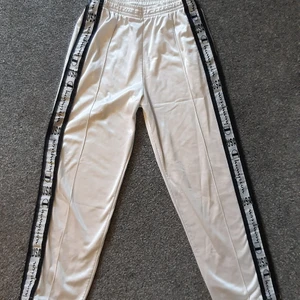 Vintage vita Champion trackies med revär - Vintage vita Champion trackies med revärer, märkta storlek S, se bilder för mått. Enstaka mindre fläckar kan förekomma. Djur- och rökfritt hem.