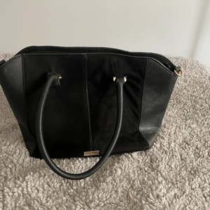 Svart väska River Island - Svart Väska med skinn och mocca-imitation från River Island. Dator och skolböcker får plats. Har ej det långa bandet, men de remmar som är på går att hänga på axeln 