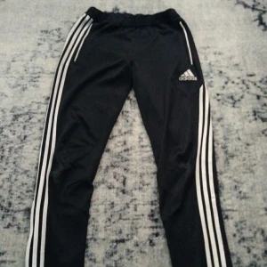 Adidas byxor med dragkedja - Adidas byxor med dragkedja, är ganska slitna på vänster och höger knä.