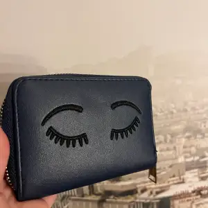 Superfin plånbok!! Mörkblå slät plånbok med ögonfransar och ögonbryn broderade! Köp för ett tag sen men aldrig använd!! Får plats med mycket.