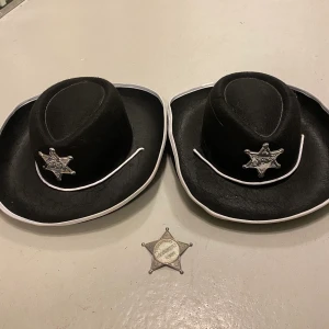 Sheriffhattar - Säljer två stycken sheriffhattar, perfekta för halloween om man vill ha matchande outfits. Medkommer även en stjärna i metall. Endast använda en kväll så fint skick. 