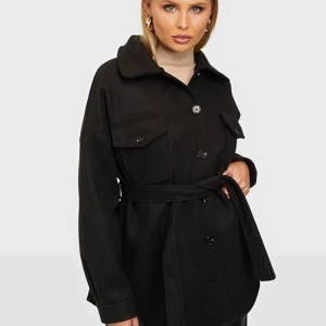 Kappa - Säljer denna svarta kappa från Nelly, storlek 32 men passar mig som brukar ha storlek 36