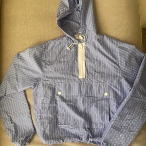 Axel Arigato Anorak strl S - Tunn anorak i oanvänt skick. Dragsko i midjan och i luvan. 2 fickor på sidan plus magficka. 