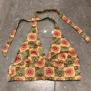 Vändbar Pull&Bear topp - En vändbar Pull&Bear topp som är orange/beige med blommor på ena sidan och ljusgrön med blommor på andra. Säljer eftersom den var för liten när jag köpte den, dvs aldrig använd. Lappen är bortklippt (för att kunna vända på den), men köpte den på Zalando💚🧡