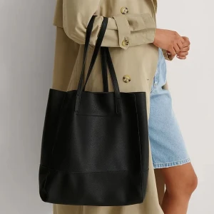 Toteväska i läderimitation  - Säljer denna väska då jag har två stycken och denna är i nyskick. Perfekt storlek att ha som skolväska då datorn ryms eller som shoppingväska! Mycket rymlig och kan både bäras på axeln, armen eller i handen. Tveka inte på att höra av dig vid frågor!❣️