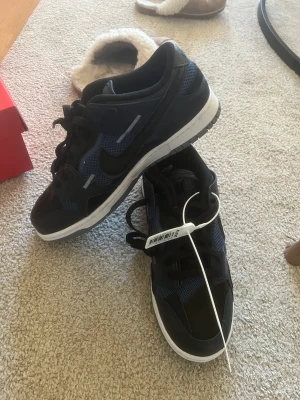Nike dunk low  - Säljer ett par oanvända nike dunk low scrap navy i storlek 42 med kartong. Kvitto finns, vill ni ha bilder hör av er