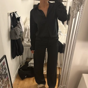 Satin set  - Säljer mitt svarta satin set från bik bok! Super snyggt men byxorna har blivit för små! Använd en gång alltså som nytt! Skjortan är i S och byxorna 34 men passar även mig som brukar ha 36. 