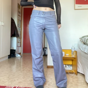Grå läderbyxor - Gråa läderbyxor med röda kontrsysömmar från gipsy. Lädret är äkta. Jag är 173cm och tycker byxorna sitter bra på mig! Har oftast S-M men byxorna är märkta med L. Tycker dock ej detta stämmer